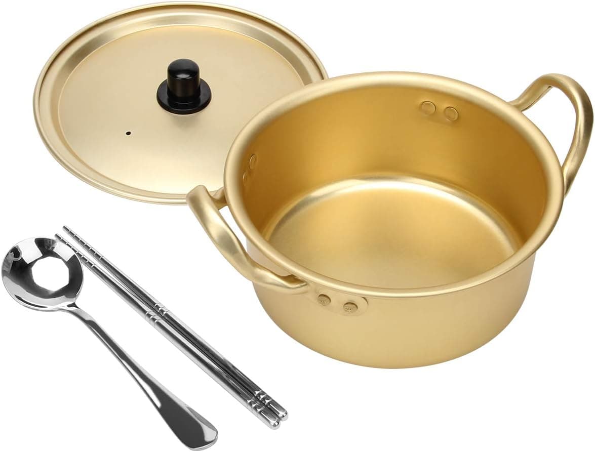 The Korean Vegan's 2025 VEGAN Holiday Gift GUIDE. 22 A golden pot with a matching lid is displayed alongside a silver spoon and a pair of chopsticks. This elegant set features two handles and sleek, shiny utensils.