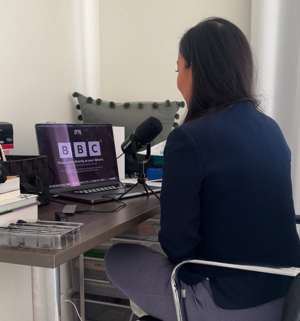 Do Laws Even Matter Any More? 2 Joanne sits at a cluttered desk, surrounded by books and office supplies, speaking into a microphone on a video call with BBC displayed on her laptop.