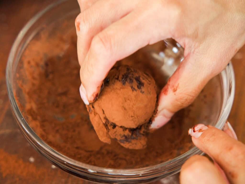 Easy & Delicious Vegan Chocolate Lava Cake Recipe. 34 A close-up of hands rolling a chocolate truffle in cocoa powder inside a glass bowl. The truffle and fingers are lightly dusted with cocoa.