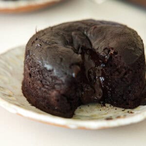 Easy & Delicious Vegan Chocolate Lava Cake Recipe. 45 A close-up of a vegan chocolate lava cake on a plate, with rich, melted chocolate oozing from the center of the moist, dark cake.