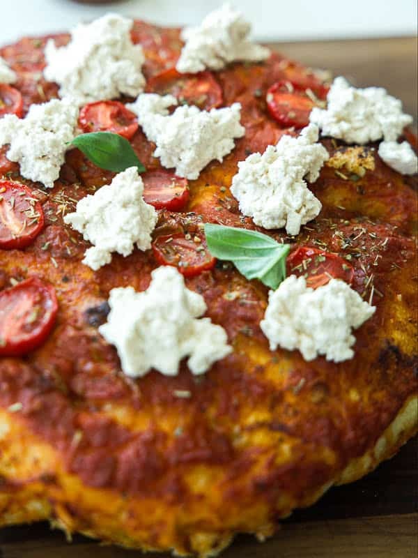 The Perfect Fluffy Focaccia Rossa Recipe - So Easy! 7 close up shot of focaccia rossa with dollop of vegan ricotta and fresh basil