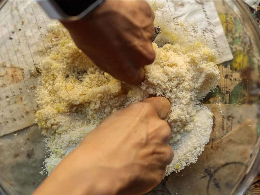 Delicious & Lemony Vegan Strawberry Shortcake Trifle. 28 a woman using her hands to massage the sugar into the lemon zest.