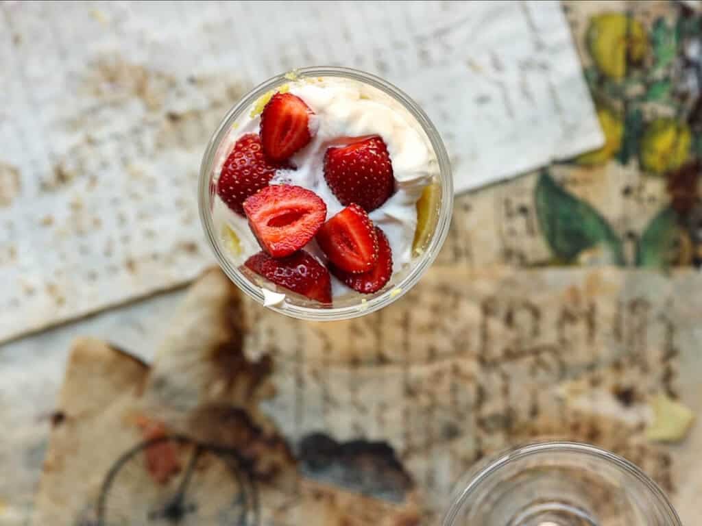 adding strawberries to trifle.