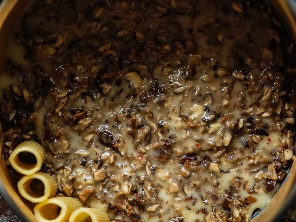 Cheesy Mushroom Rigatoni Pie - Easy Vegan Recipe. 42 mushroom béchamel and the beginning of rigatoni noodles added to springform pan.