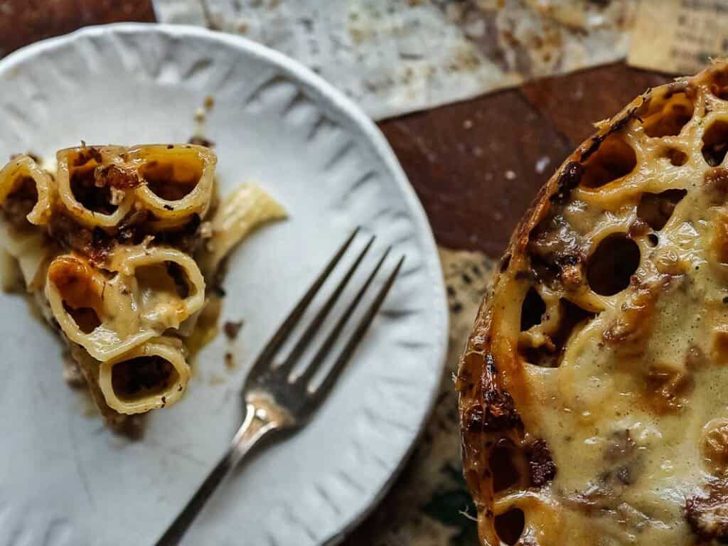 Cheesy Mushroom Rigatoni Pie - Easy Vegan Recipe. 56 top down view of mushroom rigatoni pie slice on white plate with fork.