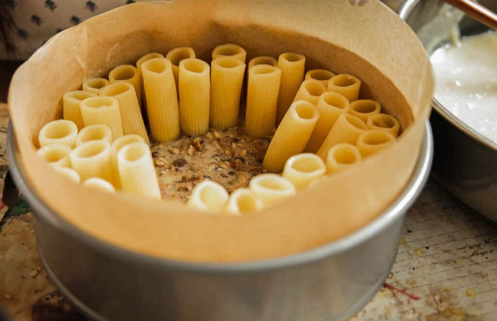 Cheesy Mushroom Rigatoni Pie - Easy Vegan Recipe. 43 springform pan filled with creamy mushroom mixture and upright rigatoni.