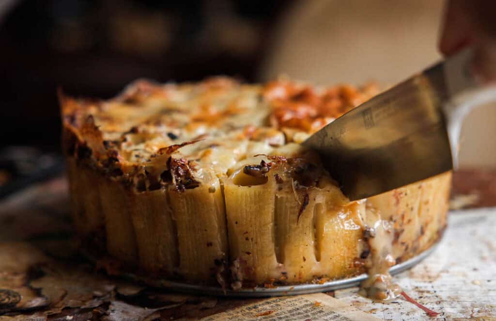Cheesy Mushroom Rigatoni Pie - Easy Vegan Recipe. 53 someone slicing mushroom rigatoni pie