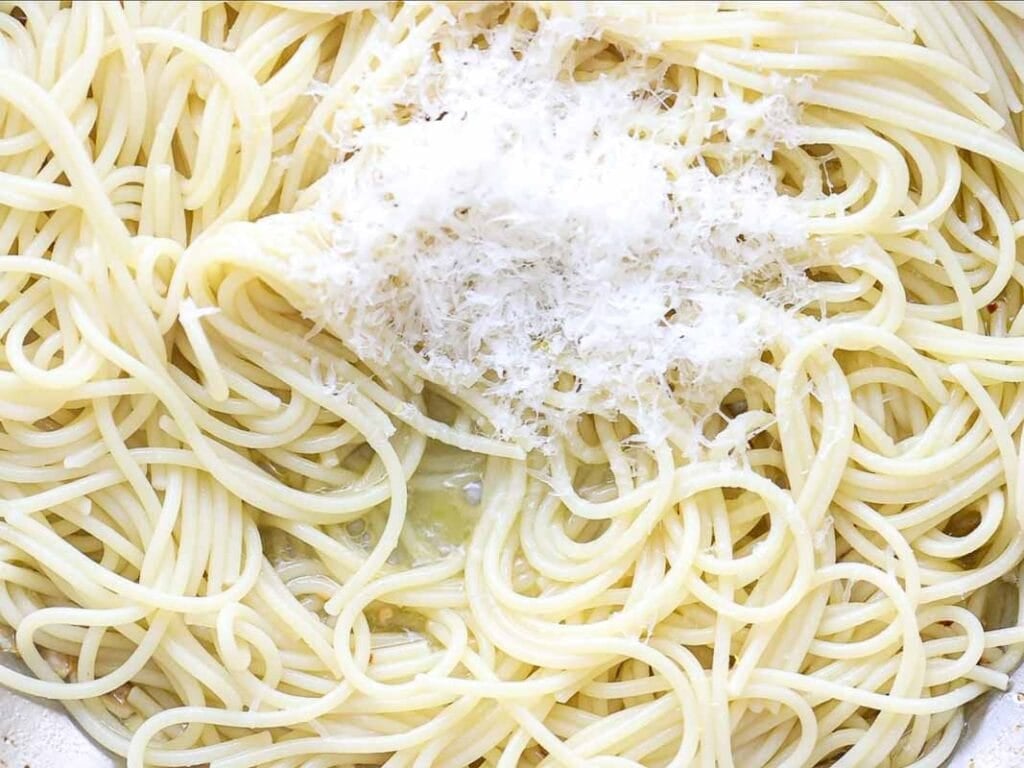 8-ingredient Easy and Delicious Lemon Pepper Pasta. 12 A close-up of cooked spaghetti topped with a mound of grated Parmesan cheese, with some melted butter or oil visible among the noodles—perfect for an Easy Lemon Pasta twist.