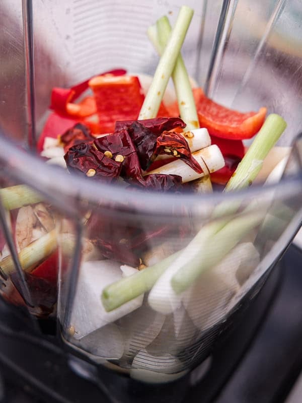 BEST Baby Bok Choy Kimchi Recipe - Easy & Delicious 31 A blender contains cut lemongrass, red bell pepper, dried red chilies, garlic, onion, bok choy kimchi, and other vegetables, ready to be blended.